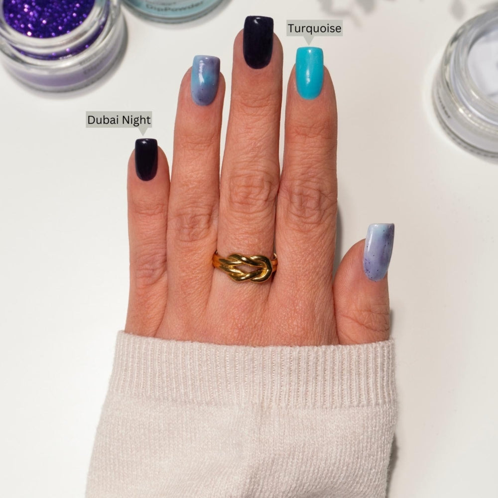 DIY-Maniküre mit DIPDRIP Dubai Night (dunkelviolett) und Turquoise (lebhaftes Blau), perfekt getwistetem goldenem Ring.